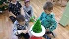Uczniowie klasy pierwszej za pomocą długopisu 3D tworzą świąteczną choinkę.